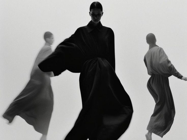 Trois silhouettes féminines en mouvement, photographiées en noir et blanc dans une ambiance épurée.